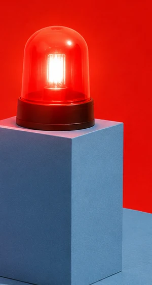 A red emergency beacon lit on a blue pedestal